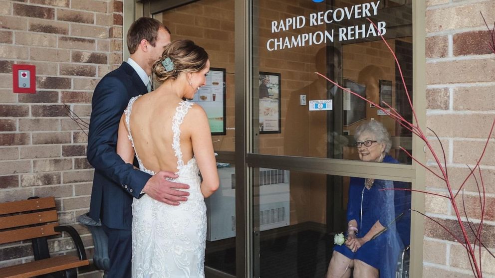 Grandma in isolation sees granddaughter through glass door on wedding day -  ABC News