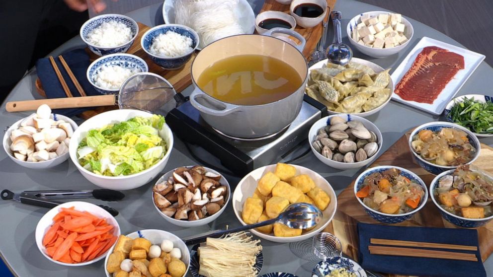 PHOTO: A table of vegetables and protein with rice, noodles and sauce for the ultimate hot pot.