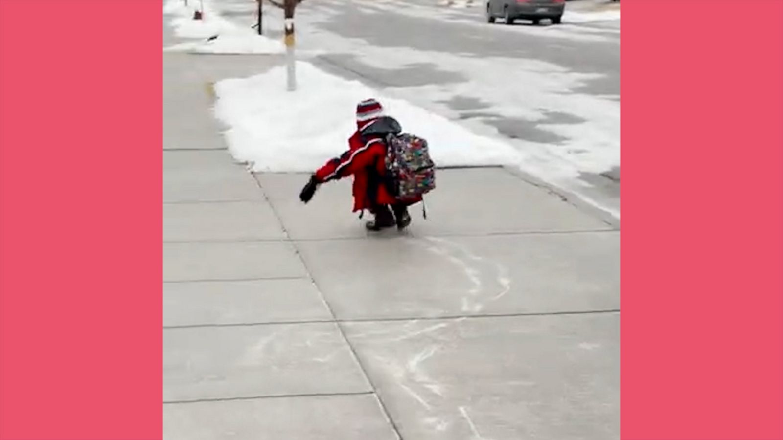 VIDEO: Little boy has fun scooting along an icy sidewalk on his way to school