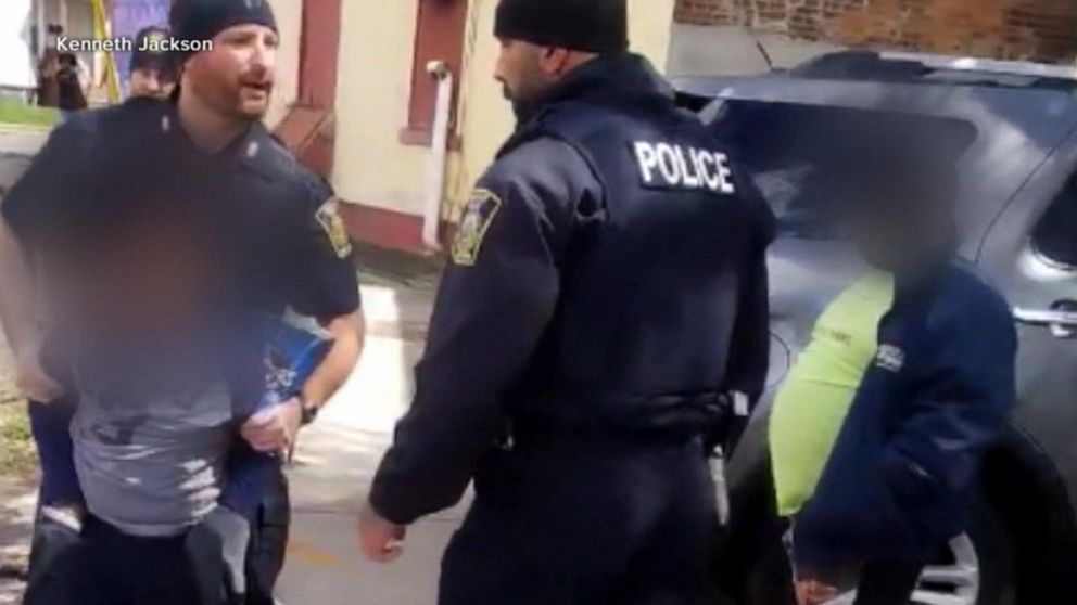 The back of a uniform Police Officer by a Police vehicle on the