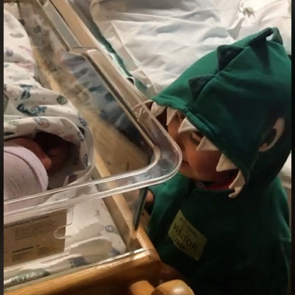sweet reaction to meeting baby brother image