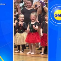 Little girl lights up after seeing family in audience