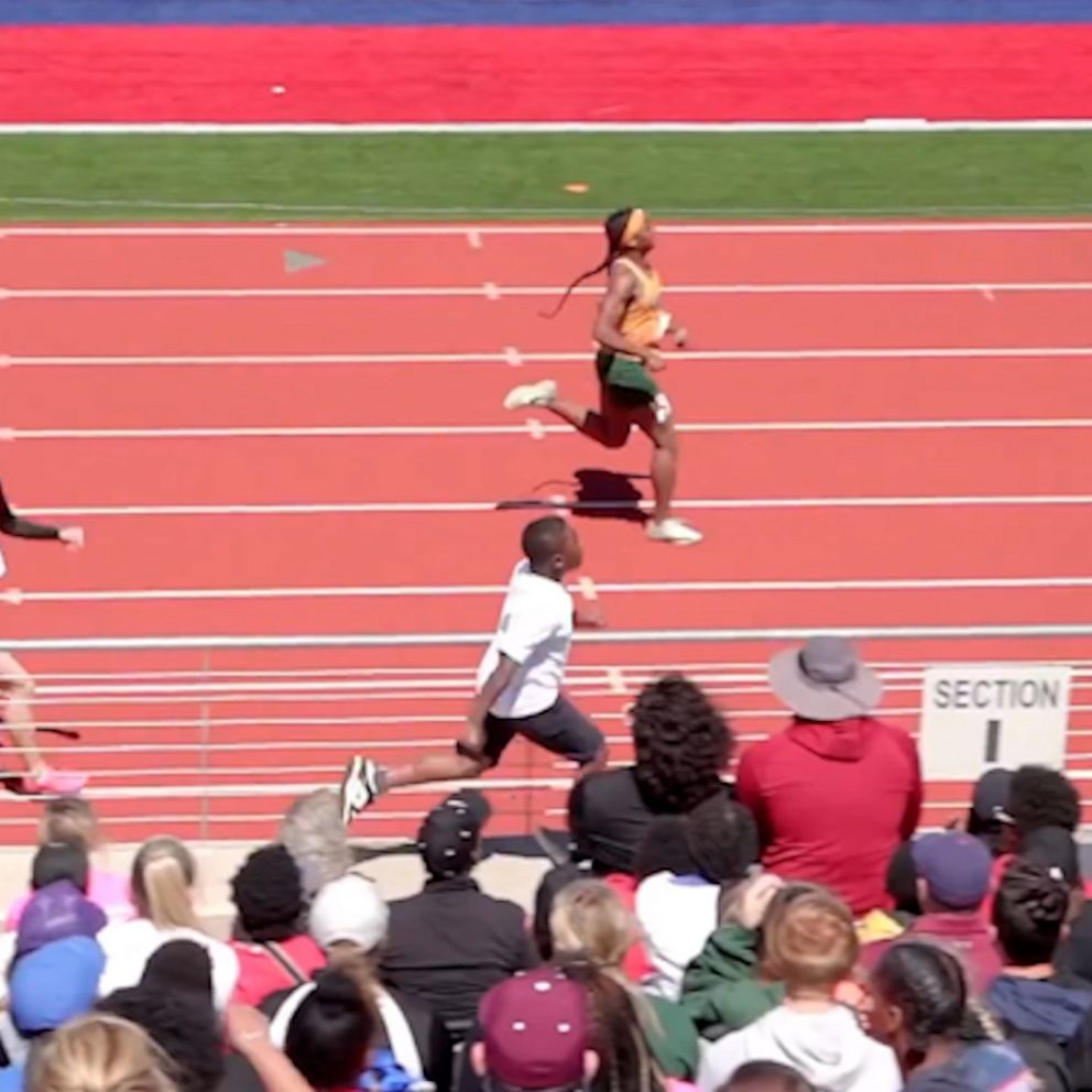VIDEO: Younger brother runs alongside stands to hype up track star sister 