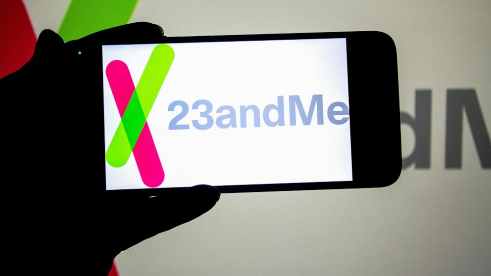 PHOTO: In this photo illustration, a 23andMe logo seen displayed on a smartphone and in the background. 