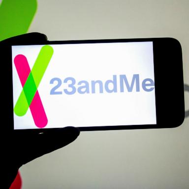 PHOTO: In this photo illustration, a 23andMe logo seen displayed on a smartphone and in the background. 