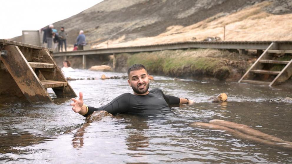 PHOTO: ABC News' Ashan Singh takes a dip in a hot spring while traveling Iceland on a budget.