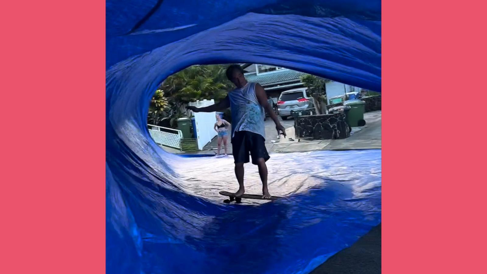 VIDEO: Surfer dad rides skateboard under a tarp like it's a wave