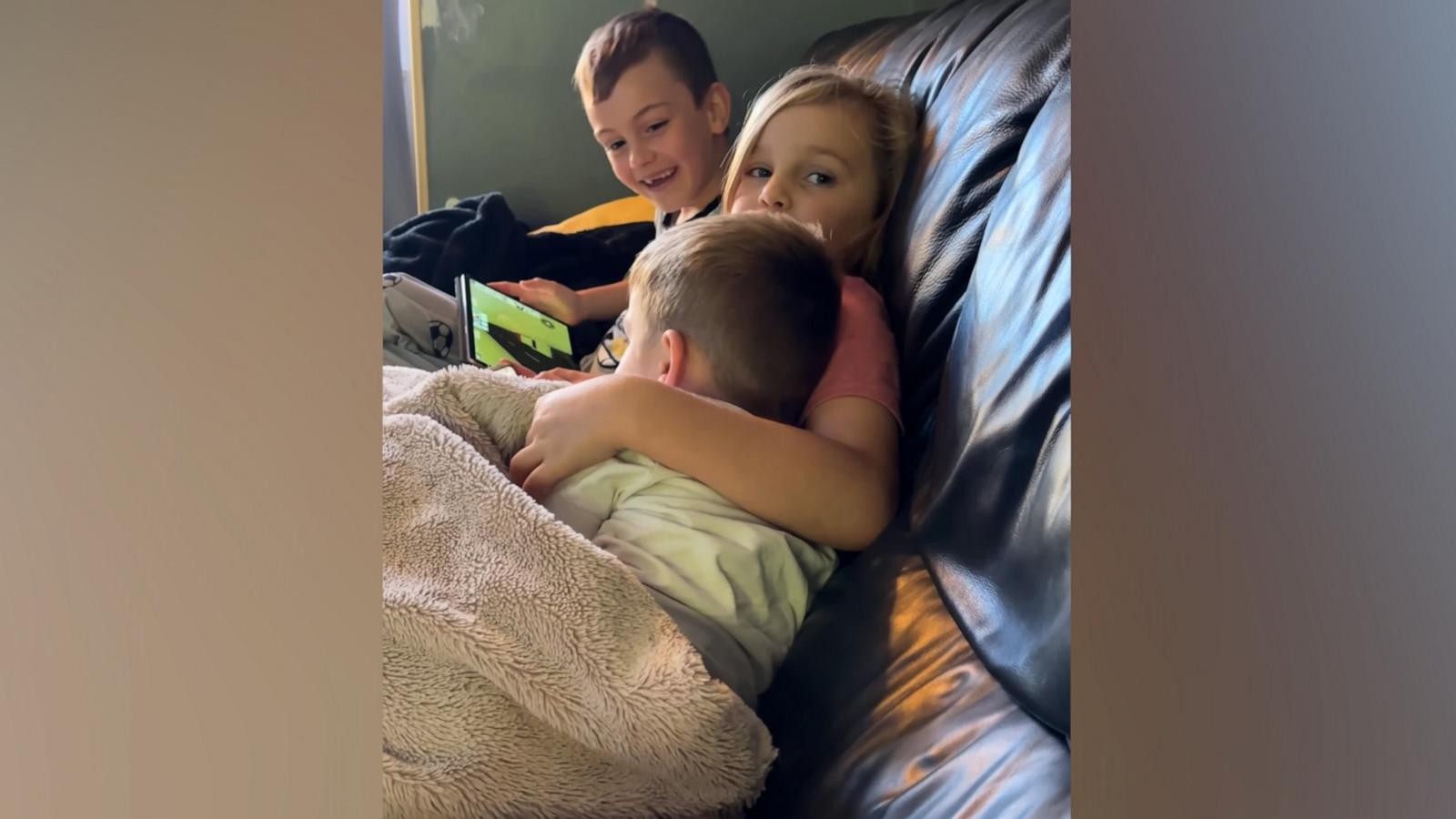 Big sister excited younger brother cuddles with her