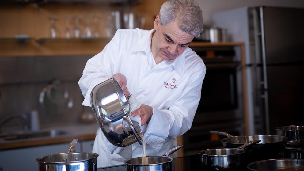 PHOTO: Chef Gabriel Kreuther pours sauce from the new Cristel cookware line. 