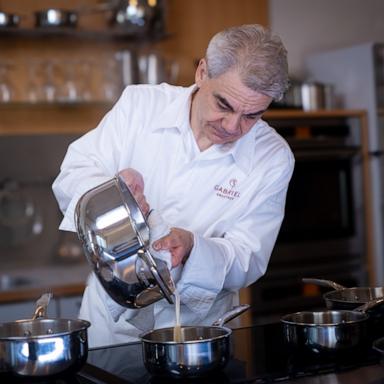 PHOTO: Chef Gabriel Kreuther pours sauce from the new Cristel cookware line. 