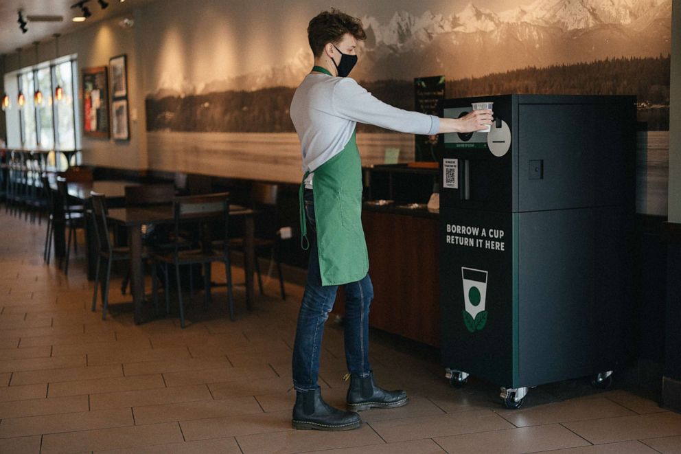PHOTO: A Starbucks employee shows how to use the reusable cup kiosk.