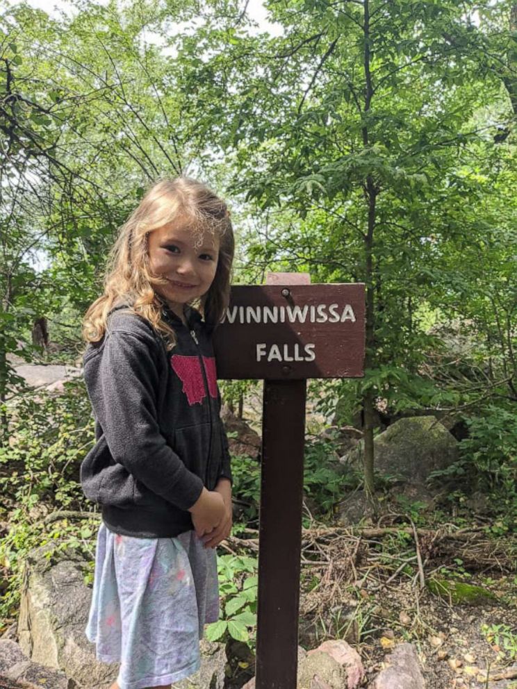 PHOTO: Wynn Radke, 5, completed her goal t osee 67 waterfalls from March to August -- ending her chase at Winnewissa Falls at Pipestone National Monument in Pipestone County, Minnesota, holding a sign and wearing a smile.