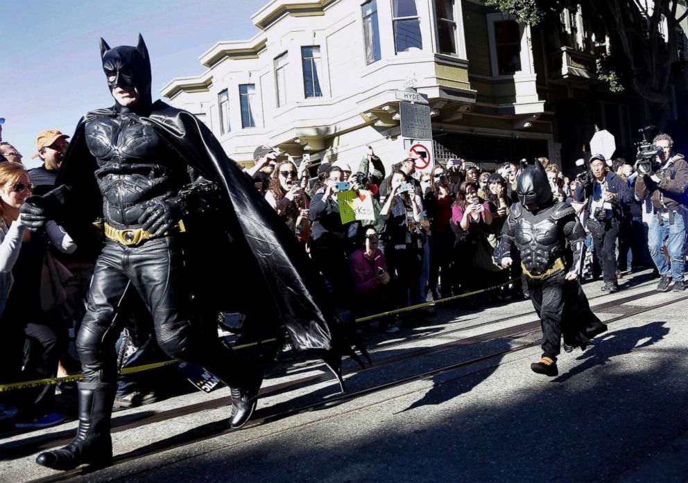 PHOTO: Miles Scott, dressed as Batkid, right, runs with Batman after saving a damsel in distress in San Francisco, Nov. 15, 2013.