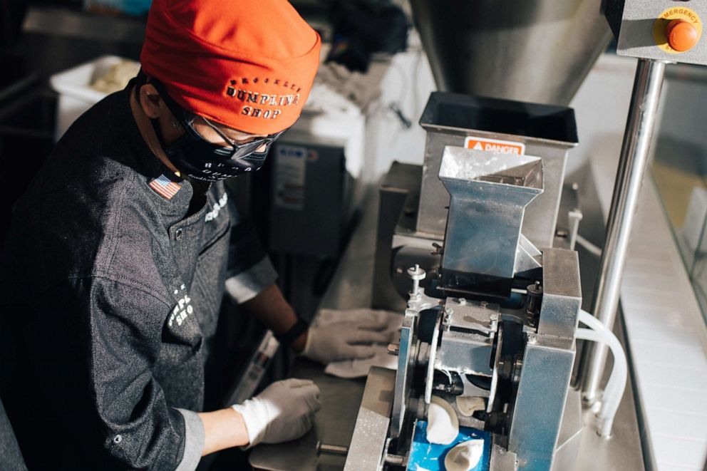 PHOTO: The chef at Brooklyn Dumpling Shop pulls fresh dumplings from the conveyor belt to cook.