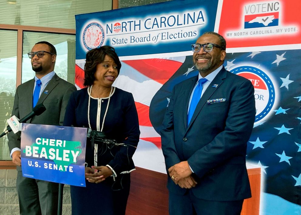 PHOTO: Democratic U.S. Senate candidate Cheri Beasley, center, laughs with husband Curtis Owens, right, while son Matthew Owens, watches, before she speaks with reporters at the North Carolina State Fairgrounds in Raleigh, N.C., Feb. 24, 2022.