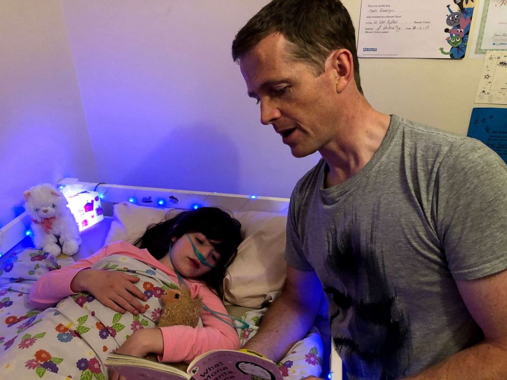 PHOTO: Chris Brannigan, 41, from England, reading a book to his daughter Hasti, 9.