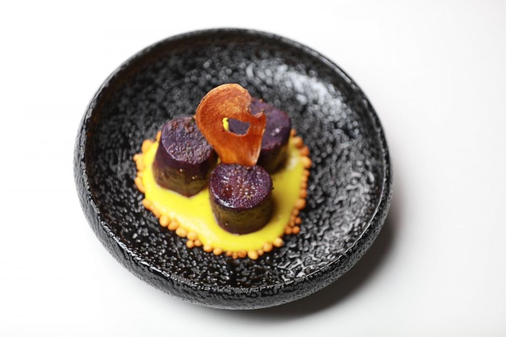 PHOTO: A plated purple sweet potato with green mango sauce and chickpea droplets from Bungalow in New York City.