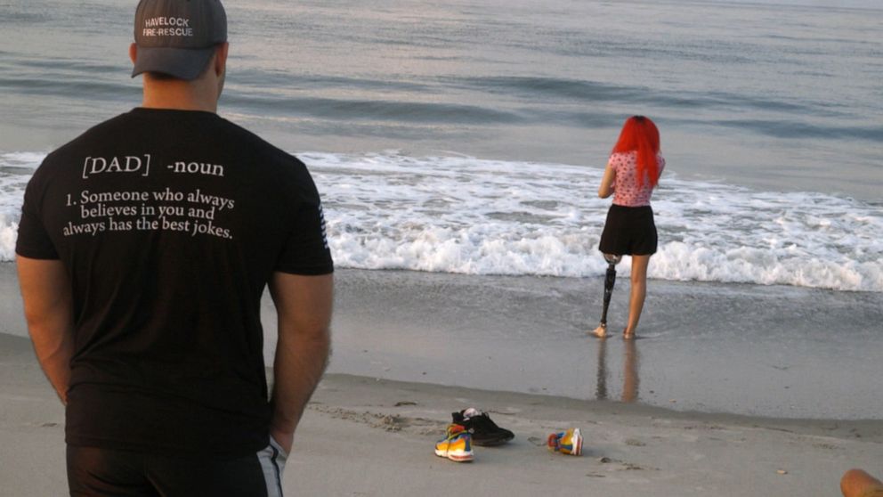 PHOTO: Charlie Winter looks at his daughter Paige Winter on the same beach where she survived a shark attack.