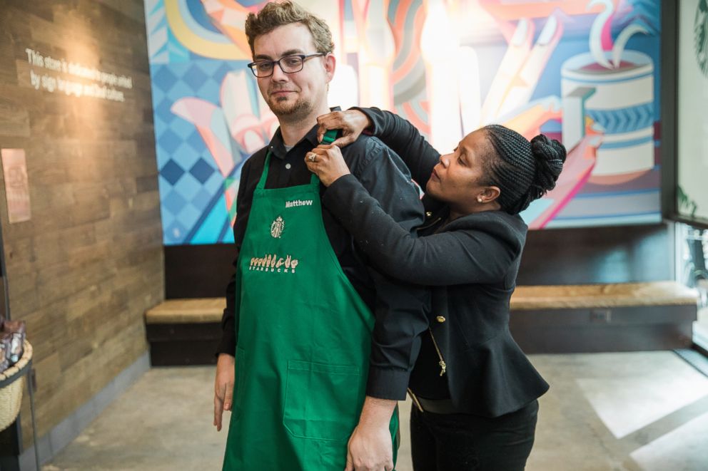 PHOTO: Starbucks District Manager Margaret Houston presents an apron to Store Manager Matthew Gilsbach on Saturday, October 20, 2018 at Starbucks first U.S. Signing Store in Washington D.C.