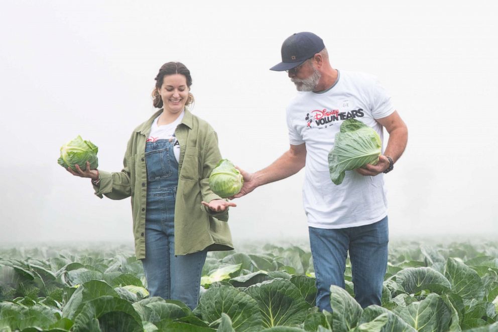 PHOTO: A Disney cast member voluntEAR with a farmer. 