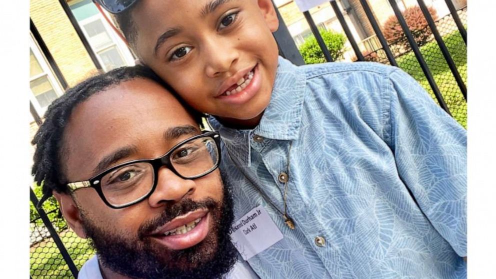 PHOTO: Desmond Durham, 36, pictured with his nine-year-old son, DJ, in front of a class of 2023 sign.