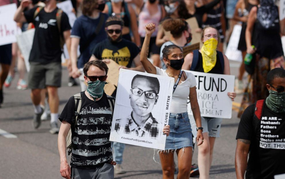 PHOTO: Demonstrators carry placards as they walk down Sable Boulevard during a rally and march over the death of 23-year-old Elijah McClain, June 27, 2020, in Aurora, Colo. 