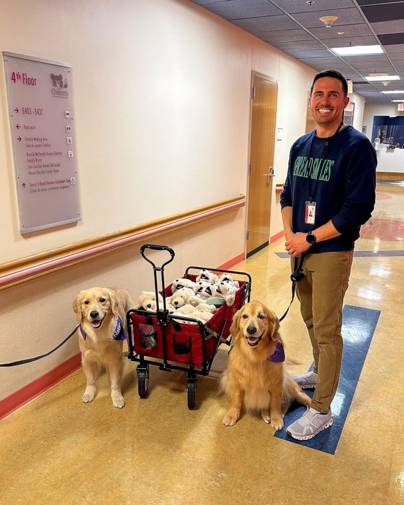 PHOTO: Kevin Bubolz, founder of Golden Retriever Life, with therapy dogs Ellie and Emma and a wagon of plush golden retriever toys.