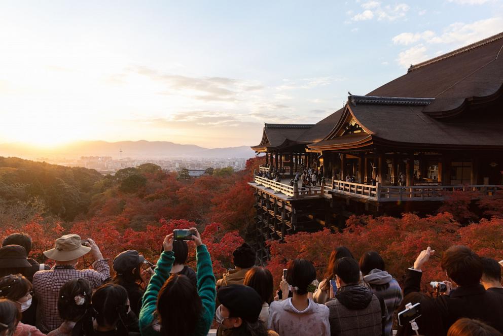 PHOTO: Visitors take photos of the Kiyomizu-dera Buddhist temple in Kyoto surrounded by Autumn leaf color, Nov. 25, 2021.