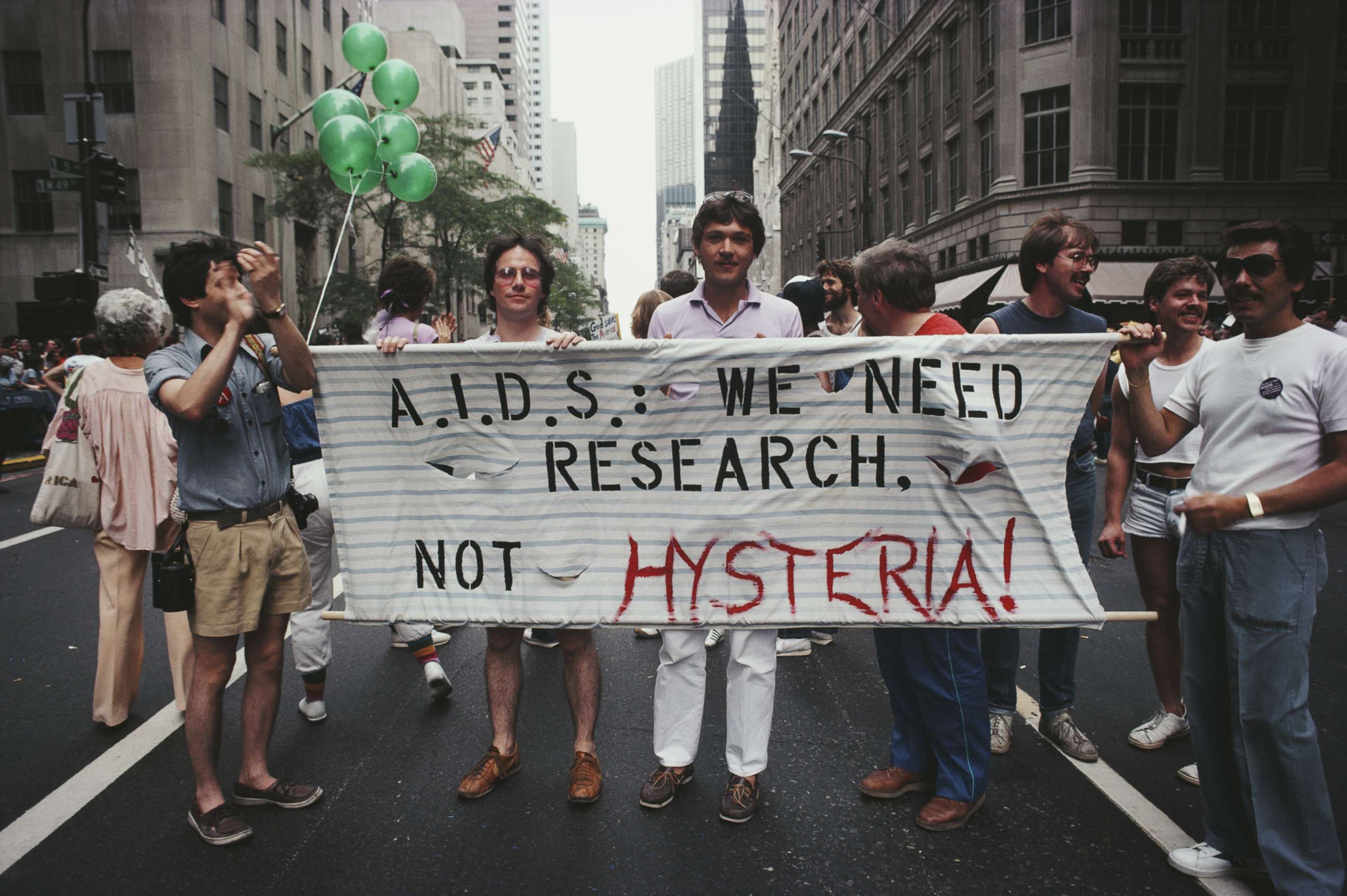 PHOTO: Marchers on a Gay Pride parade through Manhattan, New York City, carry a banner which reads 'A.I.D.S.: We need research, not hysteria!', June 1983.