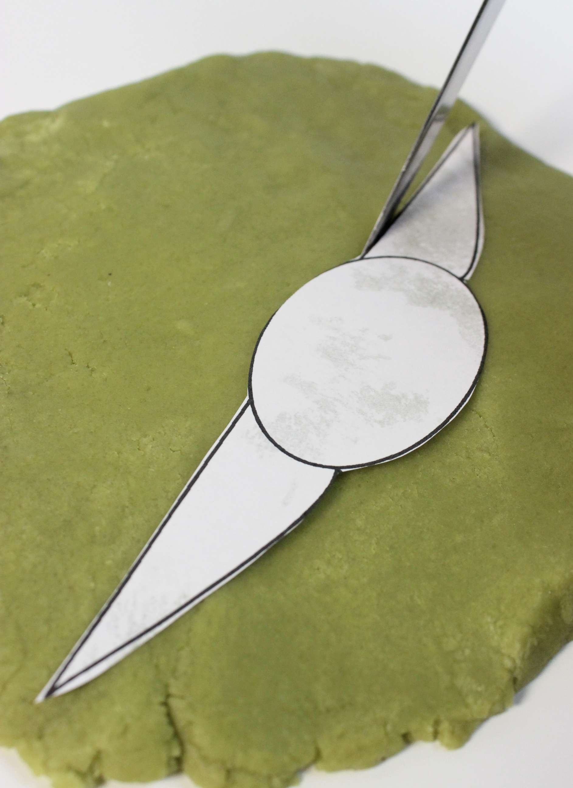 PHOTO: Grogu Tea Cookie template on top of green cookie dough.