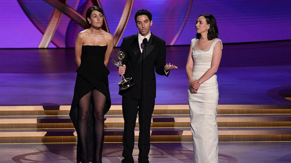 PHOTO: (From L) Writers Jen Statsky, Paul W. Downs, and Lucia Aniello accept the Outstanding Writing for a Comedy Series award for "Hacks" onstage at the 76th Primetime Emmy Awards, Sept. 15, 2024, in Los Angeles.