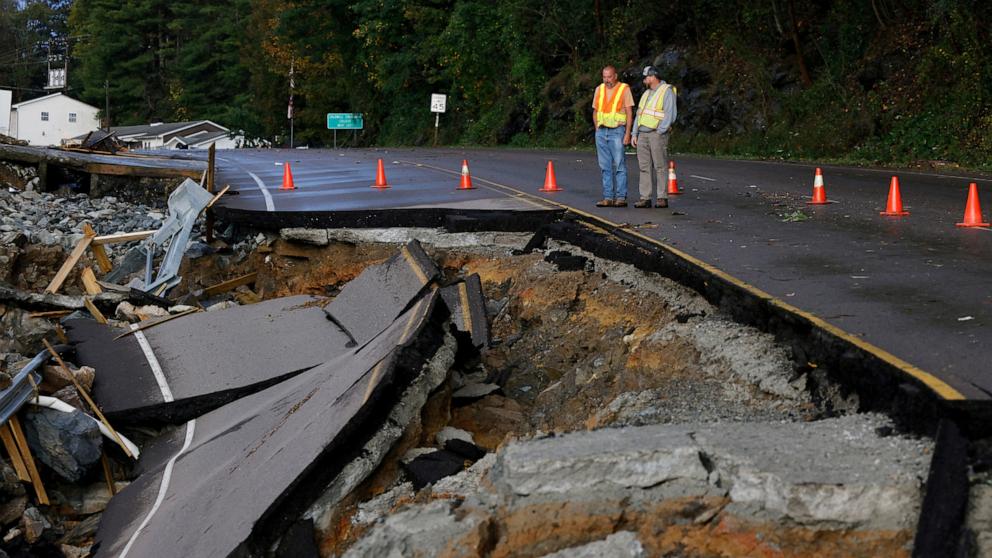 PHOTO: Workers survey a large section of Highway 105 that washed away because of flood waters during Tropical Storm Helene, on the outskirts of Boone, NC, Sept. 27, 2024. 