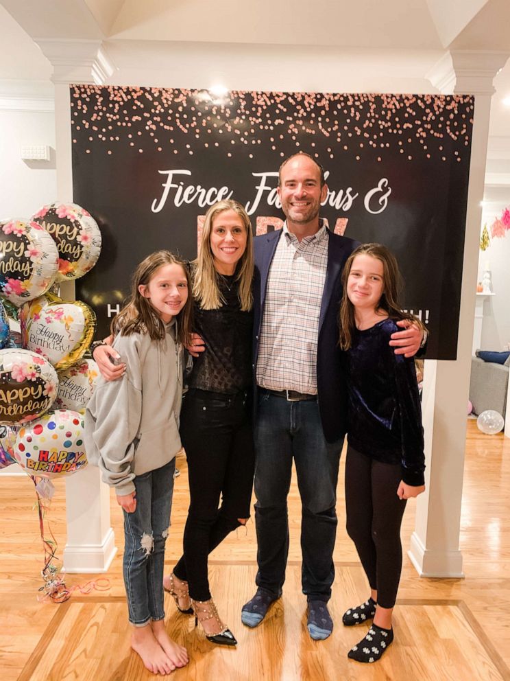 Corey Ryan and Elizabeth Long pose for a photo with Long's two daughters. 