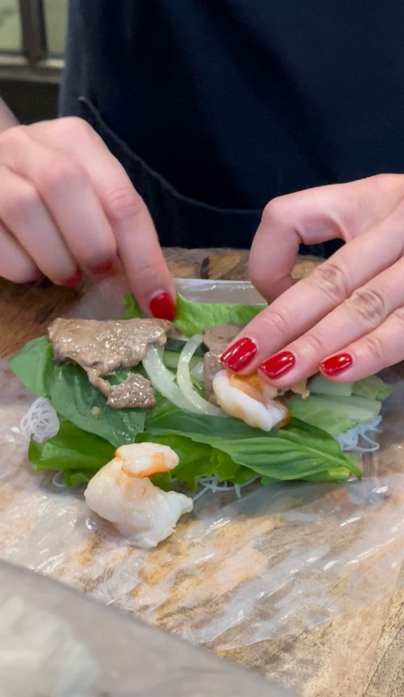 PHOTO: Lisa Nguyen rolls a Vietnamese spring roll.