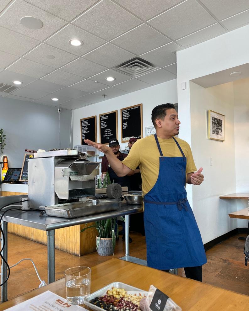 PHOTO: Milpa chef and owner DJ Flores shows how the molino works to make fresh masa.