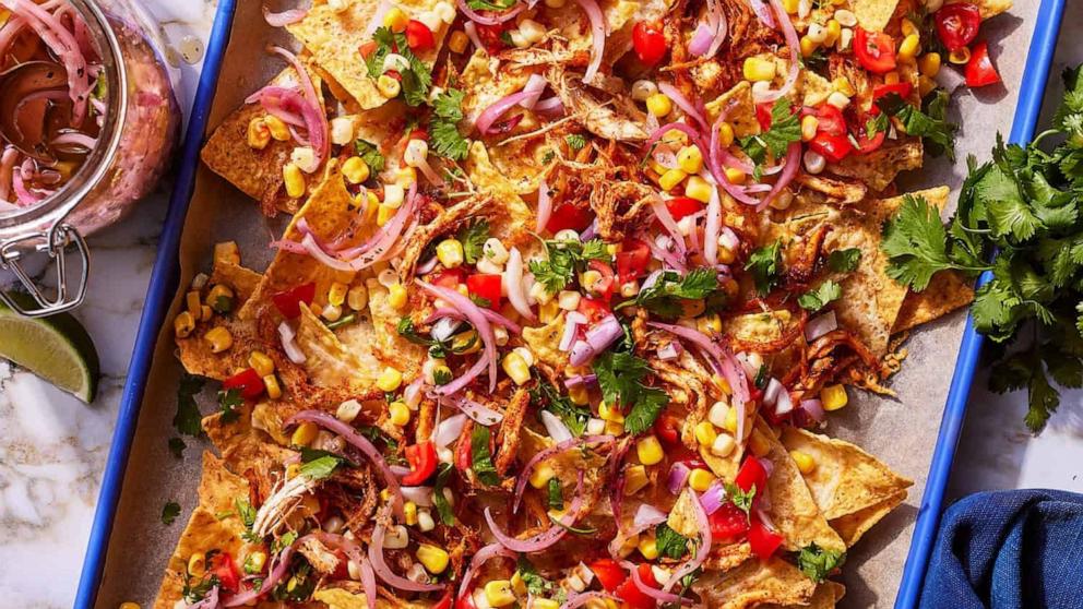 PHOTO: A sheet tray of rotisserie chicken nachos with corn salsa.