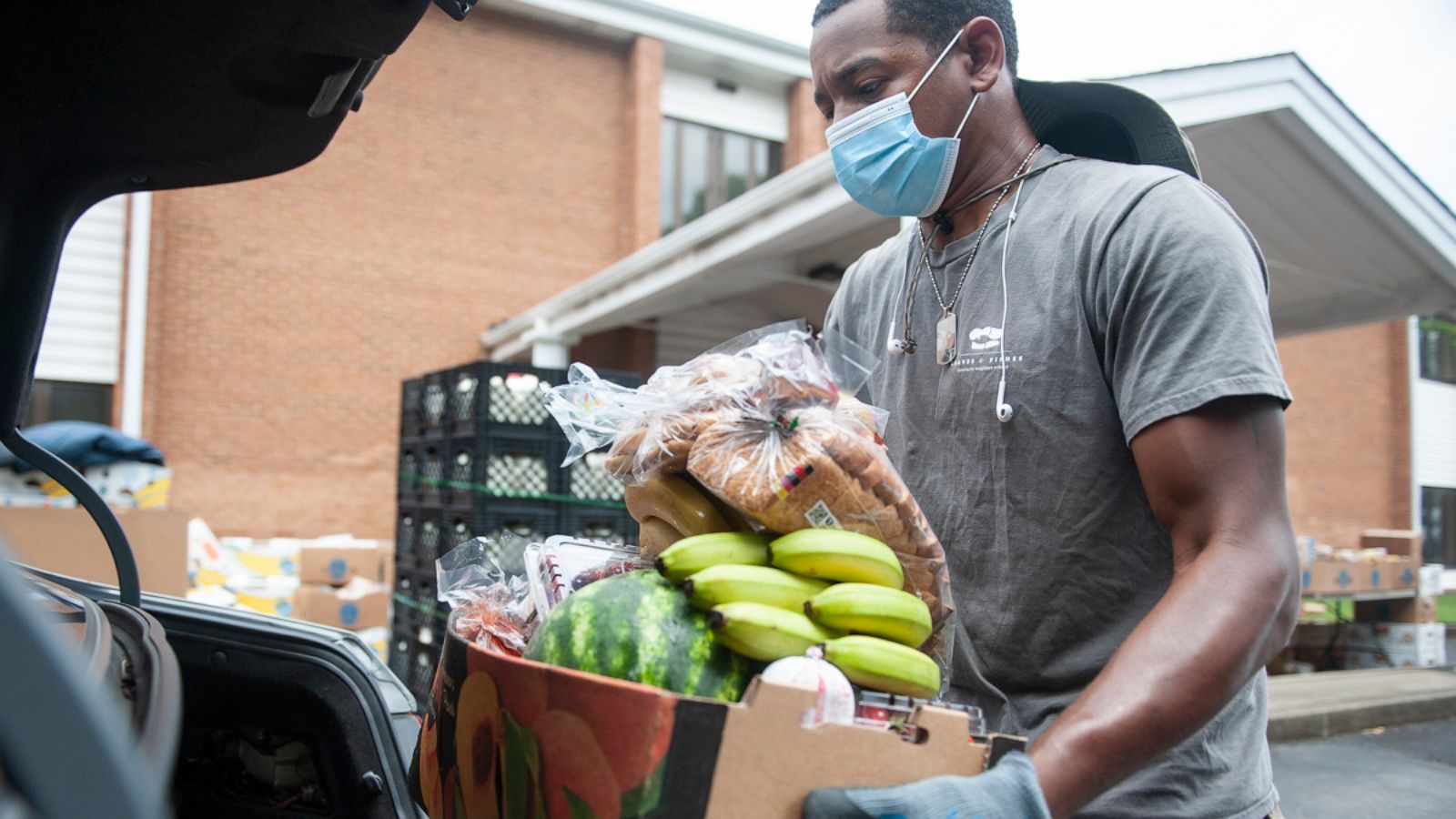 PHOTO: A Loaves & Fishes volunteer loads a box of food for donation.