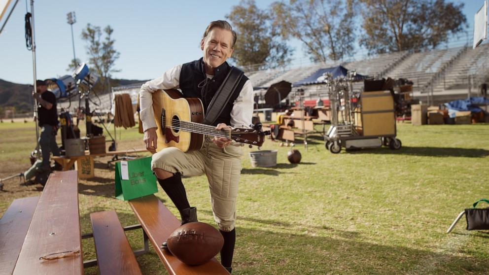 PHOTO: Kevin Bacon plays the guitar on set for a new Super Bowl campaign with Uber Eats called "Century of Cravings."