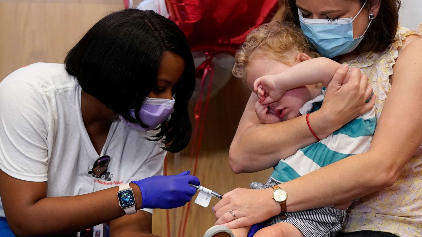 PHOTO: Leo Simon, age 2, covers his eyes as registered nurse Reisa Lancaster, left, administers a dose of a Pfizer COVID-19 vaccine at Children's National Hospital's research campus, June 21, 2022, in Washington, D.C.