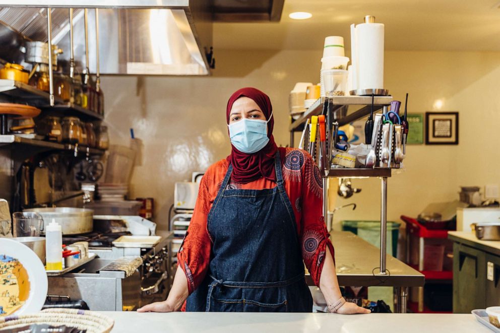 PHOTO: Kayma chef and owner Wafa Bahloul stands at her kiosk inside La Cocina Municipal Marketplace. 
