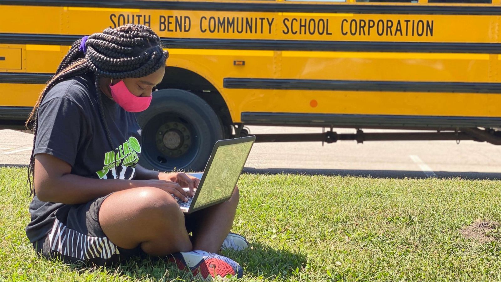 PHOTO: Leronda-Cleveland-1.jpg - Leronda Cleveland, a junior at Washington High School in South Bend, Ind., sits on the grass outside one of South Bend Community School Corporation's Wi-Fi buses.