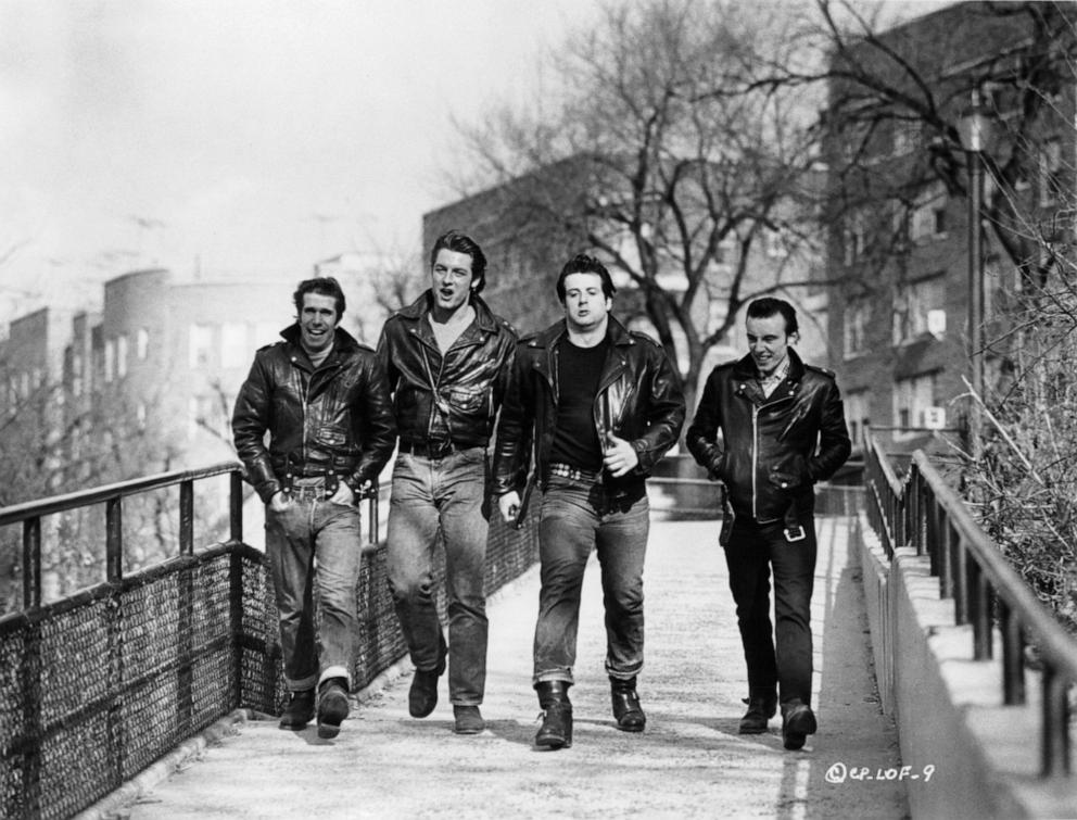PHOTO: Henry Winkler, Perry King, Sylvester Stallone, and Paul Mace on walkway in a scene from the film "The Lords Of Flatbush," 1974. 