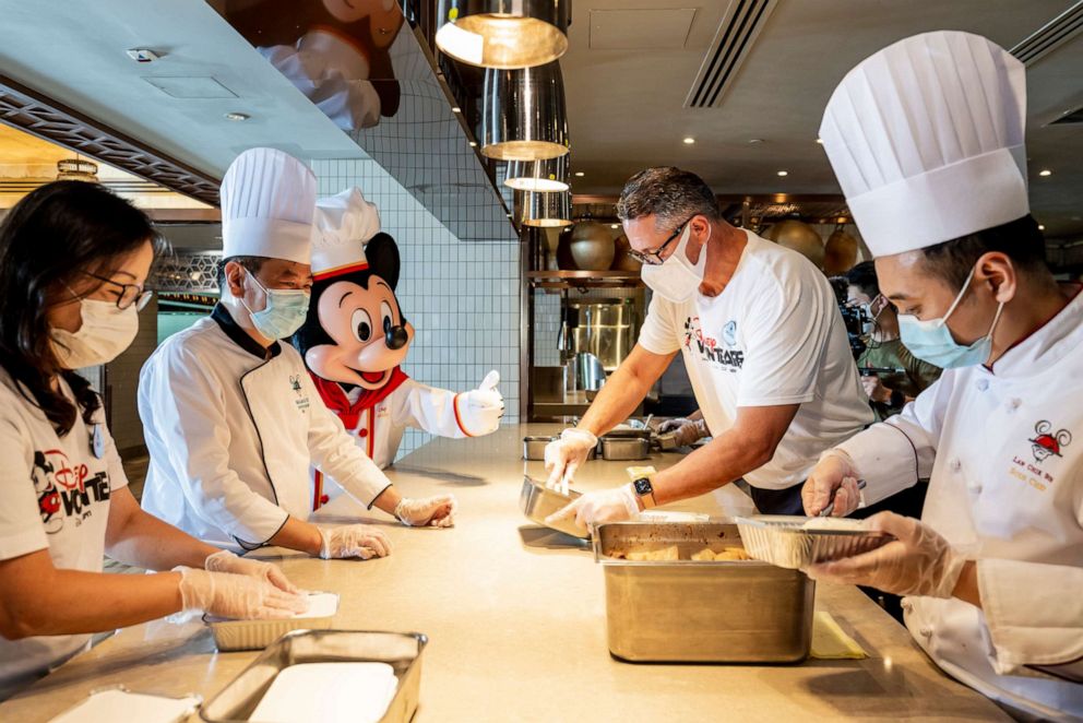 PHOTO: Chefs prepare meal boxes in a kitchen with Disney VoluntEARS.