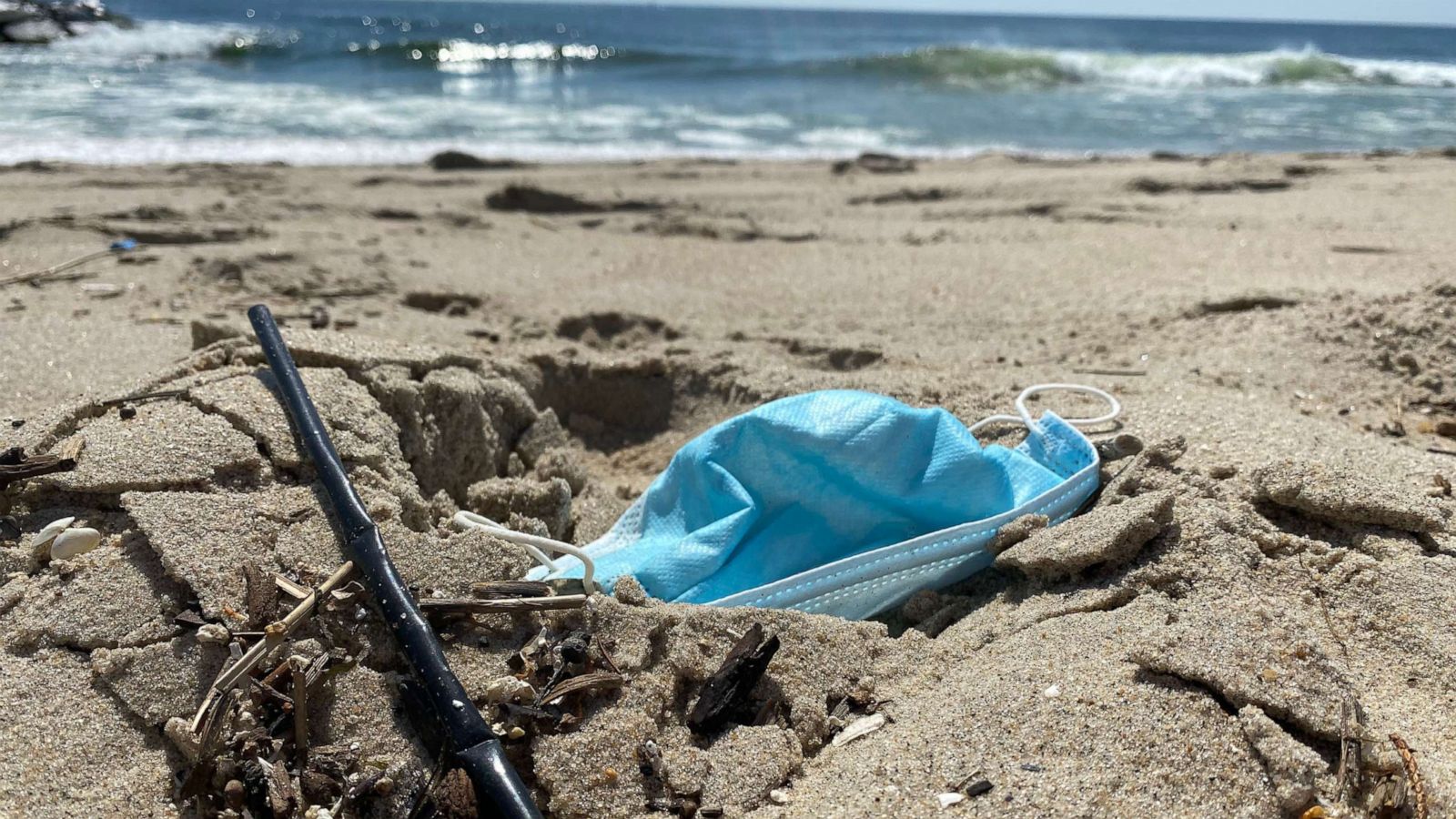 PHOTO: Stray face mask and straw on beach in New Jersey.