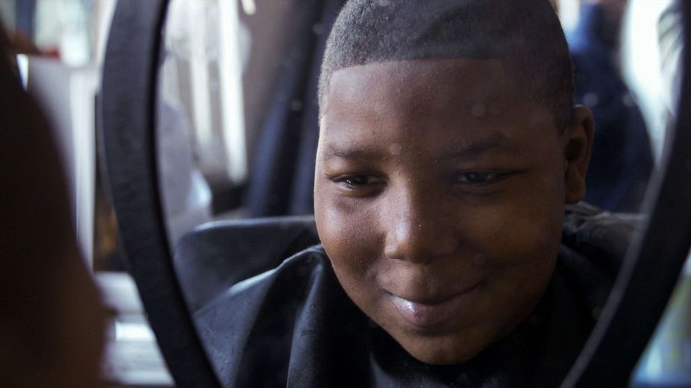 PHOTO: A student observes his haircut after a scheduled appointment with Principal Dr. Terrance Newton at Warner Elementary School.
