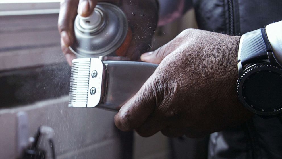 PHOTO: Principal Dr. Terrance Newton cleans his hair supplies before his next scheduled appointment with a student at his Warner Elementary School barbershop.