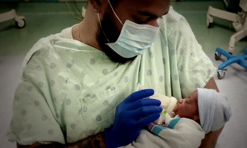 PHOTO: Omari Maynard is pictured feeding his newborn son.
