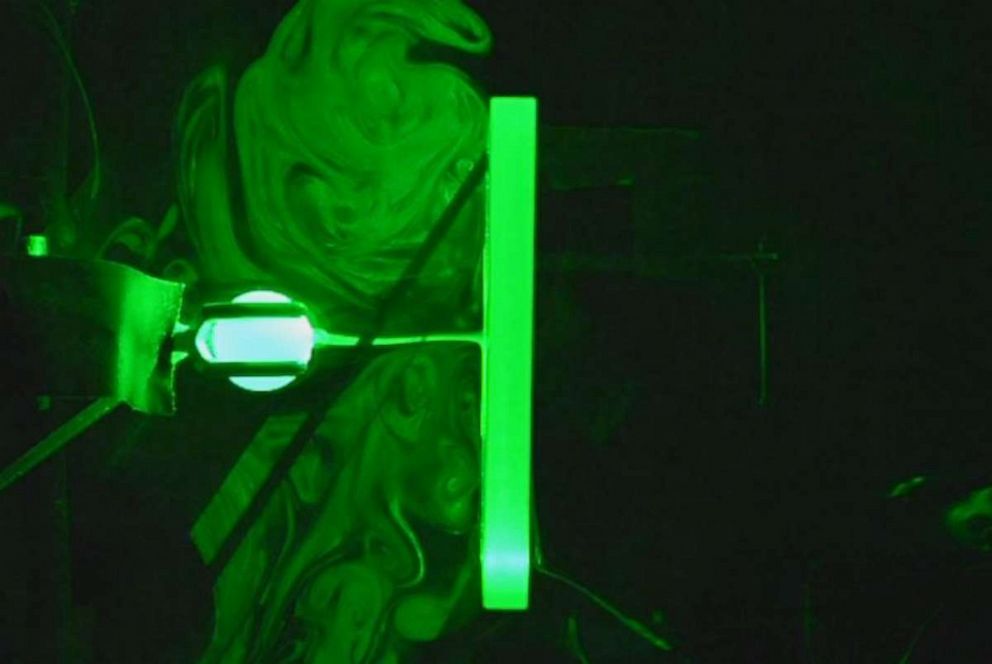 Still image from demonstrations conduced at Princeton University's engineering lab visualize how plexiglass dividers affect the flow of particles similar to a situation when a person is inhaling and exhaling in front of a plexiglass divider.