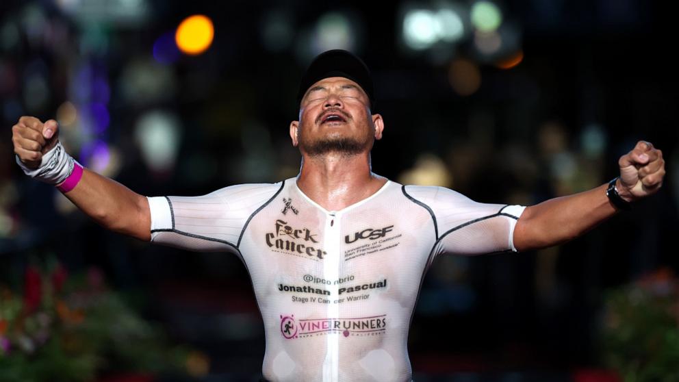 PHOTO: Jonathan Pasqual of United States celebrates completing the VinFast IRONMAN World Championship, Oct. 26, 2024, in Kailua Kona, Hawaii. 