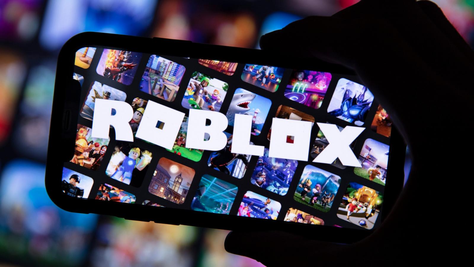 PHOTO: LA person holds a smartphone displaying the Roblox game logo.